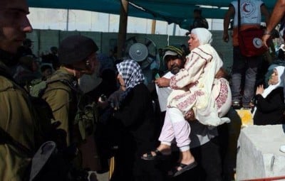 صورة.. يحمل والدته عبر الحاجز الاحتلالي للصلاة في القدس