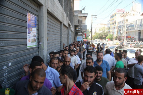 بالصور ..موظفي حكومة غزة  السابقة  يتقاضون رواتبهم عبر البريد والبنك الوطني الاسلامي   دنيا الوطن
