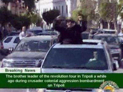 القذافي يظهر في سيارة مكشوفة بطرابلس مرتديا قبعة خضراء