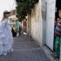 مصور إسرائيلي يلتقط صورة لفتاة يهودية في عيد المساخر وهي تبصق على طفل فلسطيني
