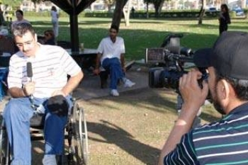 مذيع يقدم الأخبار لفضائية العربية على كرسي متحرك