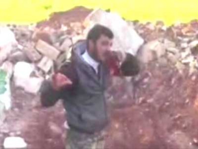 من سوريا .. بعد نزع قلب جندي والتهامه فتى يقطع رأس اسير و جندي يقطع العضو التناسلي لجثة
