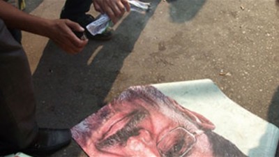 معتصمو "الدفاع" يضعون صورة "مرسي" على الأرض