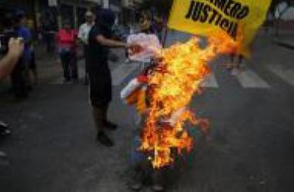 محتجون يشتبكون مع الشرطة ويحرقون دمى للرئيس في فنزويلا