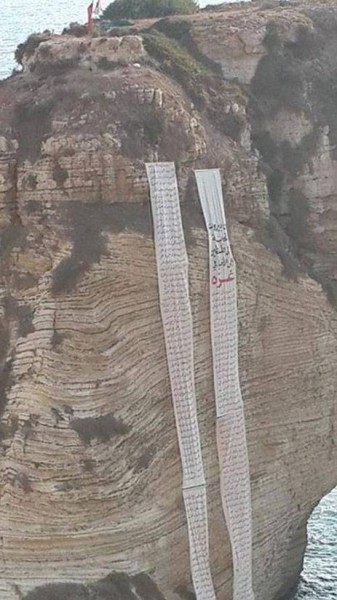 لبنانيون يعلقون أسماء شهداء غزة على صخرة الروشة في لبنان