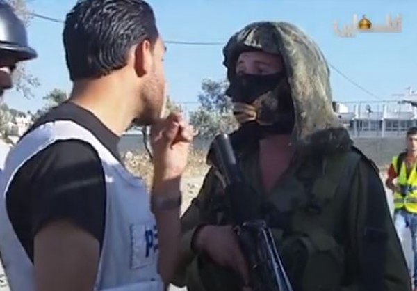 الصحفي جهاد القاضي يرد على أحد الجنود بعد مضايقته خلال التغطية أمام مدخل مخيم الجلزون
