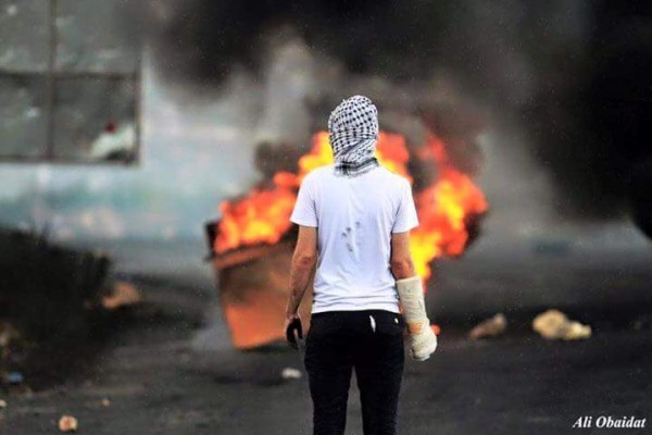 صورة:ملثم"بيد مكسورة" يصبح رمزا للإصرار الفلسطيني في الخطوط الامامية للمواجهات في البيره