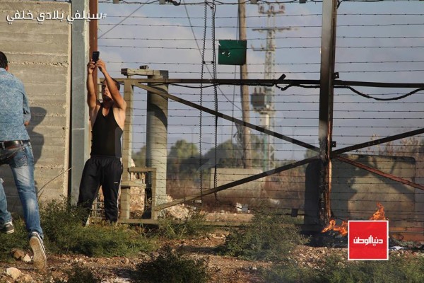 متظاهر غزي يلتقط صورة مع الأراضي المحتلة ..#سيلفي_بلادي_خلفي