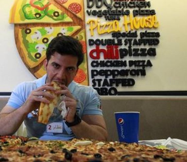 صور: رجل يأكل بيتزا قطرها 80 سنتيمتراً في ساعة واحدة فقط!