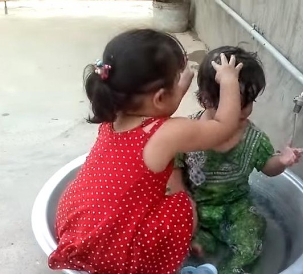 بالفيديو .. طفلة عراقية جميلة تمارس دور أمها على أختها الصغيرة