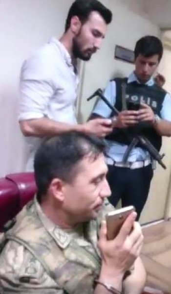 عناصر الشرطة التركية تجبر أحد العناصر الإنقلابية التي تم اعتقالها لمحادثة العناصر الأخرى للانسحاب والاستسلام