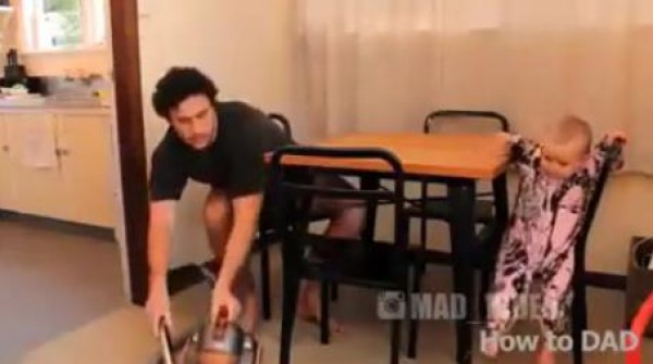 أب يقوم بتعليم طفلة كيفية أداء المهام المنزلية