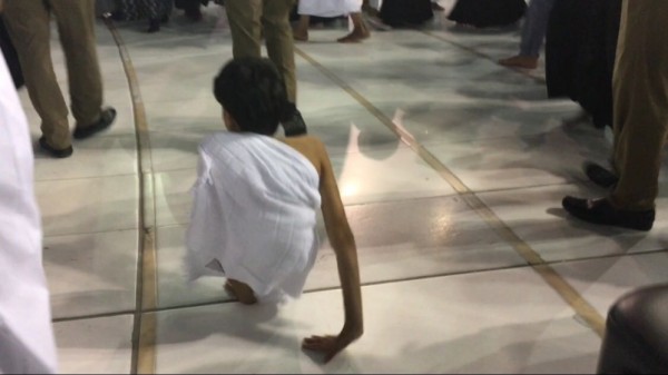 شاب بنصف جسد يطوف 7 أشواط حول الكعبة على يديه