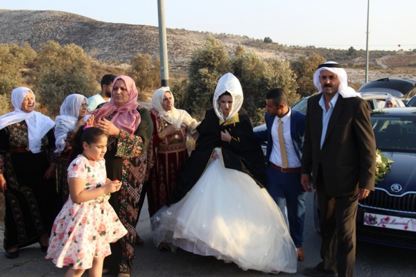 العروسان "محمد ونهال" يعبران الحاجز مشياً على الأقدام