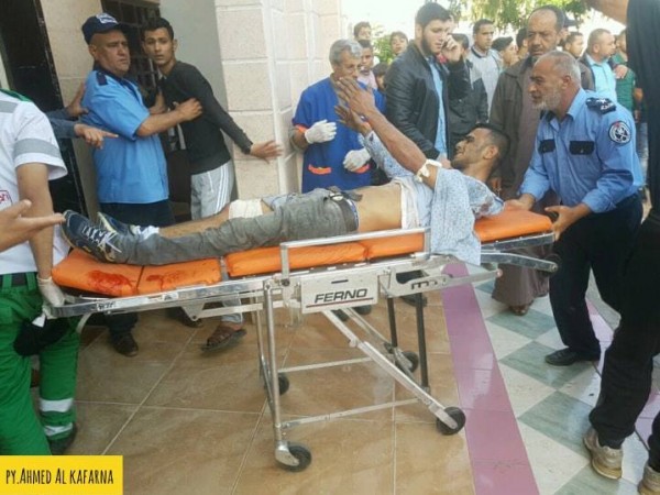 صورة: رجل يستقبل نجله المصاب بأحد مستشفيات القطاع