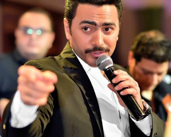 شاهد.. ما هي قصة الفتاة التي قام تامر حسني بتقبيل رأسها؟