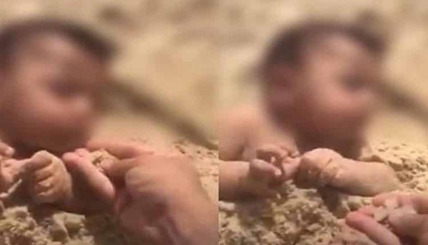 فيديو مروع لرجل يدفن طفلاً في الرمل ويلقمه التراب