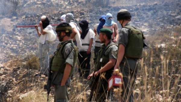 توثيق مستوطنين مُلثمين وهم يقذفون الحجارة على مدرسة فلسطينية