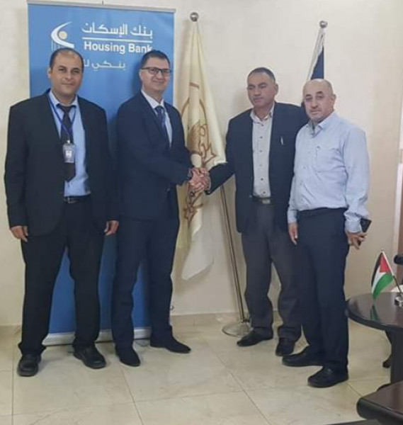 بنك الاسكان فرع حلحول يقدم منحة لتأهيل دوار الذروة لبلدية حلحول