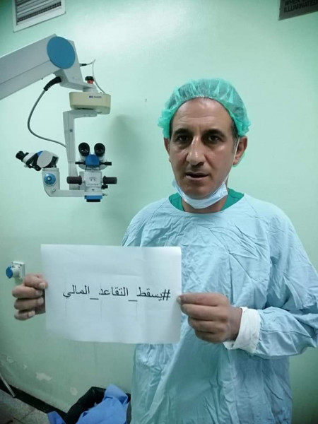 طبيب بغزة يرفع لافته بـ"غرفة عمليات" مستشفى مكتوب عليها "يسقط التقاعد المالي"