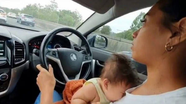 رصد أم ترضع طفلها خلال القيادة على طريق سريع
