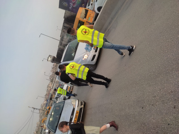 متطوعو النضال الشعبي يوزعون الماء والتمر على المواطنين على حاجز قلنديا